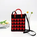 Schwarze Stricktasche mit roten 3D-Herzen, kurzen Henkeln und einem Schultergurt - Herz Handytasche-Schwarz Rot