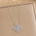 Macro shot of silver clover pendant with sparkling zircon on a beige textured display box - Silver Necklace (557)