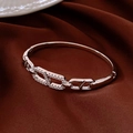 Macro detail van zilveren schakelarmband met kristallen op bruin satijnen stof - Ovale Kettingsluiting Stijl / Zilver