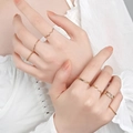Close-up of a layered gold ring set featuring heart shapes and woven bands on model hands - 7-Piece Set (1866) / 7-Piece Set / KC Gold