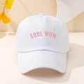 Close-up of a white cotton baseball cap featuring pink COOL MOM embroidered lettering - White