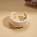 Detalle de brazalete de resina crema grueso con textura de mármol artístico y diseño abierto - Estilo de Resina de Mármol Blanco Crema