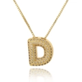 Detailed macro view of gold letter D pendant with micro-paved cubic zirconia stones - Letter D