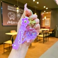 Handheld detail of purple Sakura liquid shaker keychain with glitter and golden bell - Purple Luminous Bubble Bead Lollipop