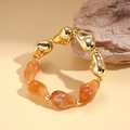 Detail view of retro acrylic beaded bracelet with gold metal and orange resin geometric beads - Light Coffee