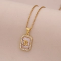 Vue macro du collier en or 18 carats avec pendentif rectangulaire en nacre et lettre R - Lettre R