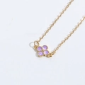 Collar minimalista de oro con un colgante de trébol de cuatro hojas morado en el fondo - Trébol Morado