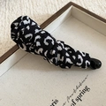 Détail d'une pince à cheveux à imprimé léopard avec texture plissée sur un plateau - Pince Bec de Canard (HH9274) / Imprimé Léopard Noir et Blanc