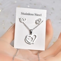 Close-up of silver stainless steel jewelry set with hollow double heart design on card - TT-167 Hollow Double Heart