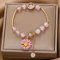 Pink beaded bracelet with daisy charm and gold finish displayed on a silk gift box - Pink Crackle Bead Daisy Pendant Bracelet (3985)