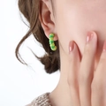 Orecchini a cerchio a C in smalto verde e oro con design a spirale indossati da modella - Verde