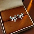 Close-up of silver bow stud earrings with blue gemstones in a velvet jewelry box - Silver-Blue (S925 Silver Needle)