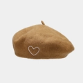 Detalle de la boina de lana camello con bordado de corazón blanco y textura de fieltro - Camel