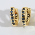 Detailed view of gold hoop earrings with row-set dark blue cubic zirconia stones - Royal Blue
