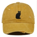 Close-up of black cat embroidery and distressed details on a mustard yellow cotton cap - Orange