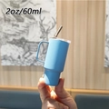 Detail showing hand holding 2oz blue stainless steel mini tumbler with straw - 2oz/60ml / Blue