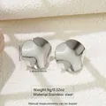Close-up of wavy irregular silver stainless steel earrings on a stone surface - Irregular Ripple