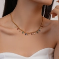 Golden necklace with multi-colored teardrop gemstones worn by a model in close-up - Multicolor Water Drop Style