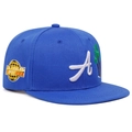 Gros plan détaillé d'une casquette bleue à bord plat avec broderie blanche et écusson latéral - Réglable / Bleu