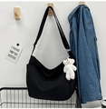 Close-up of black canvas messenger bag with cute bear charm and adjustable shoulder strap - With Bear Pendant / Black