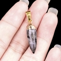 Natural amethyst agate bullet pendant with gold plating clasp shown in hand - Larvikite