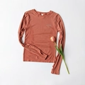 Détail d'un haut de sport rouge brique à manches longues avec passe-pouces - Rose