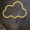 Cloud shaped neon night light with warm yellow glow on a white circular stand - Warm White Cloud
