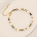 Detalle de pulsera de cuentas con piedra natural verde, perlas y cadena de extensión dorada - Ágata Dendrítica