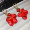Vue détaillée des boucles d'oreilles fleurs mates rouges avec spirales dorées et perles - Style Crochet / Rouge