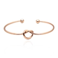 Detail view of a rose gold knotted cuff bracelet with end beads and polished finish - Rose Gold