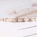 Detailed close-up of natural pink crystal stones on a golden metal hairpin base - Rutilated Quartz + Gold Clip