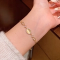 Elegant gold bracelet featuring an oval cat's eye stone and zircon accents on a wrist - S749 Gold