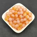 Detailed view of 8mm orange and translucent white gradient glass beads in a white dish - 8mm / A5# Orange Gradient (8MM)