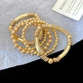 Detalle de un juego de cuatro pulseras doradas con cuentas lisas y tubos en espiral - 6# Pulsera Dorada (Set de 5 piezas)