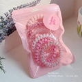 Close-up of six pink spiral telephone cord hair ties in a branded thank you pouch - 6# Pink Series