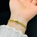 Golden woven bracelet featuring a black evil eye charm with intricate eyelash details - Black Evil Eye Bracelet / Gold