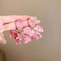 Dettaglio di orecchini a fiore in resina rosa marmorizzata con petali stratificati - Orecchini a Bottone Fiore Rosa / Motivo marmo rosa