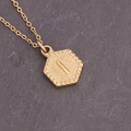 Macro view of gold hexagonal letter I necklace with sunburst edges and matte finish - Letter I (9#I)