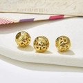 Macro shot of three vintage gold hollow round alloy beads with geometric texture for DIY jewelry - Style 28