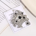 Macro shot of silver flower basket brooch with black and white crystals on display card - Style 6 (Contrast Color Flower Basket)