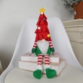 Weihnachtswichtel mit langen Beinen und Baumhut auf weißen Büchern zur Dekoration - Roter langbeiniger Zwerg