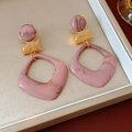 Détail de boucles d'oreilles géométriques en résine marbrée rose dans un coffret - Clou d'oreille en argent - Rose