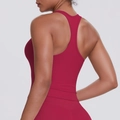 Macro detail of the racerback design on a burgundy sports vest for women's fitness - Carmine
