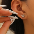 Silver starfish stud earrings with realistic textured finish on a model's ear - Silver (X491)