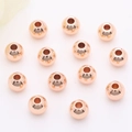 Makroaufnahme von roségoldenen Zwischenperlen mit strukturierter Oberfläche - 2mm / Roségold