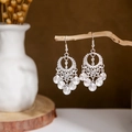 Detailed close-up of bohemian silver earrings with leaf hollow patterns and round tassels - Silver Hollow Disc Tassel(E2875-01)