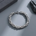 Detailed close-up of a silver Byzantine chain bracelet with a lobster clasp on a stone base - 5mm*22cm / Steel