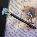Detail of vintage black metal pen with gold claws holding a raw blue lapis stone - Lapis Lazuli