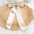 Elegant beige satin oversized bow hair clip on decorative tray with ribbon detail - Duckbill Hair Clips / Apricot