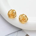 Dettaglio macro di orecchini a spirale traforati placcati in oro 18K su ceramica bianca - Oro 18K / Oro